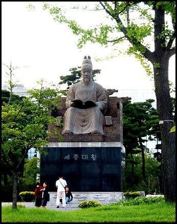 백성을 사랑한 세종임금의 동상, 동상 앞에 젊은이들이 대화를 나누고 있다. 